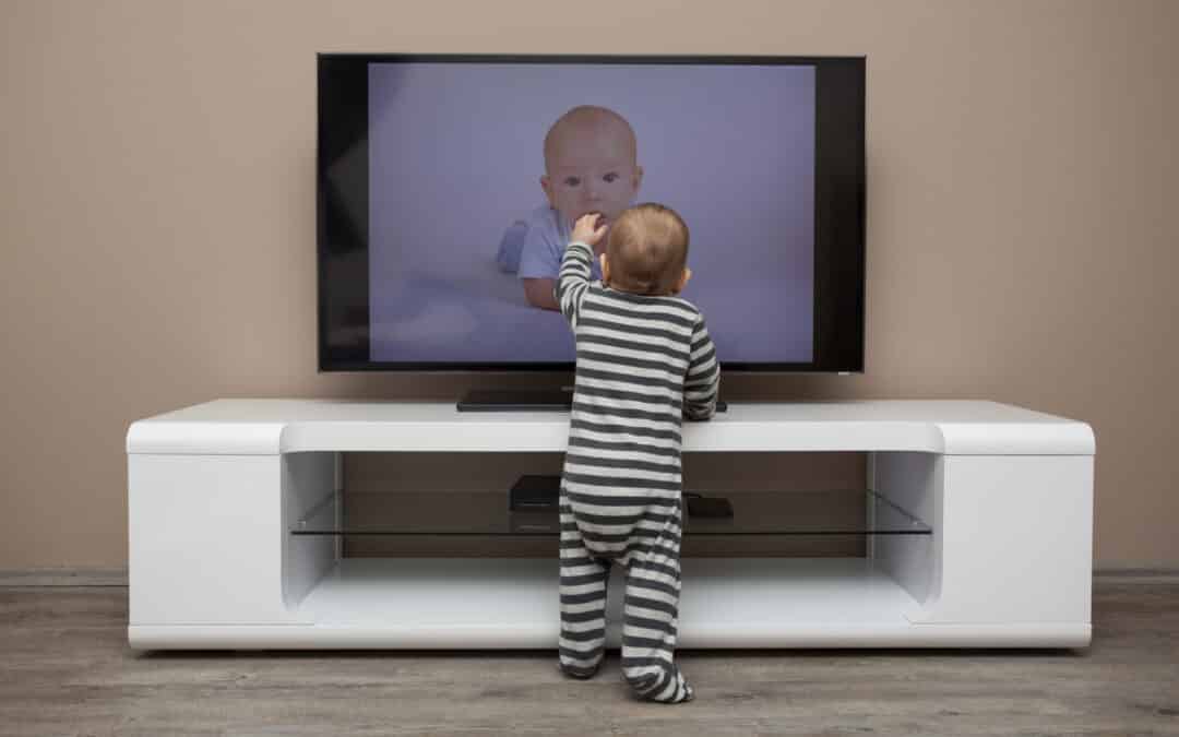 baby in front of a TV on a stand